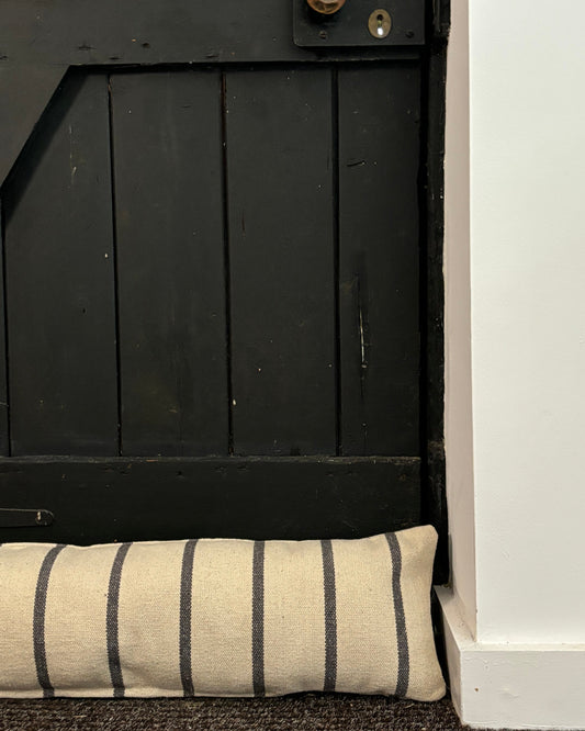 Black wooden cabinet with a striped cushion on a white background